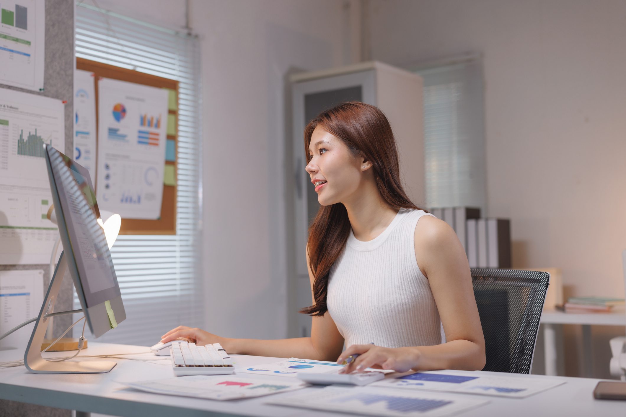 Woman working at desk with computer.