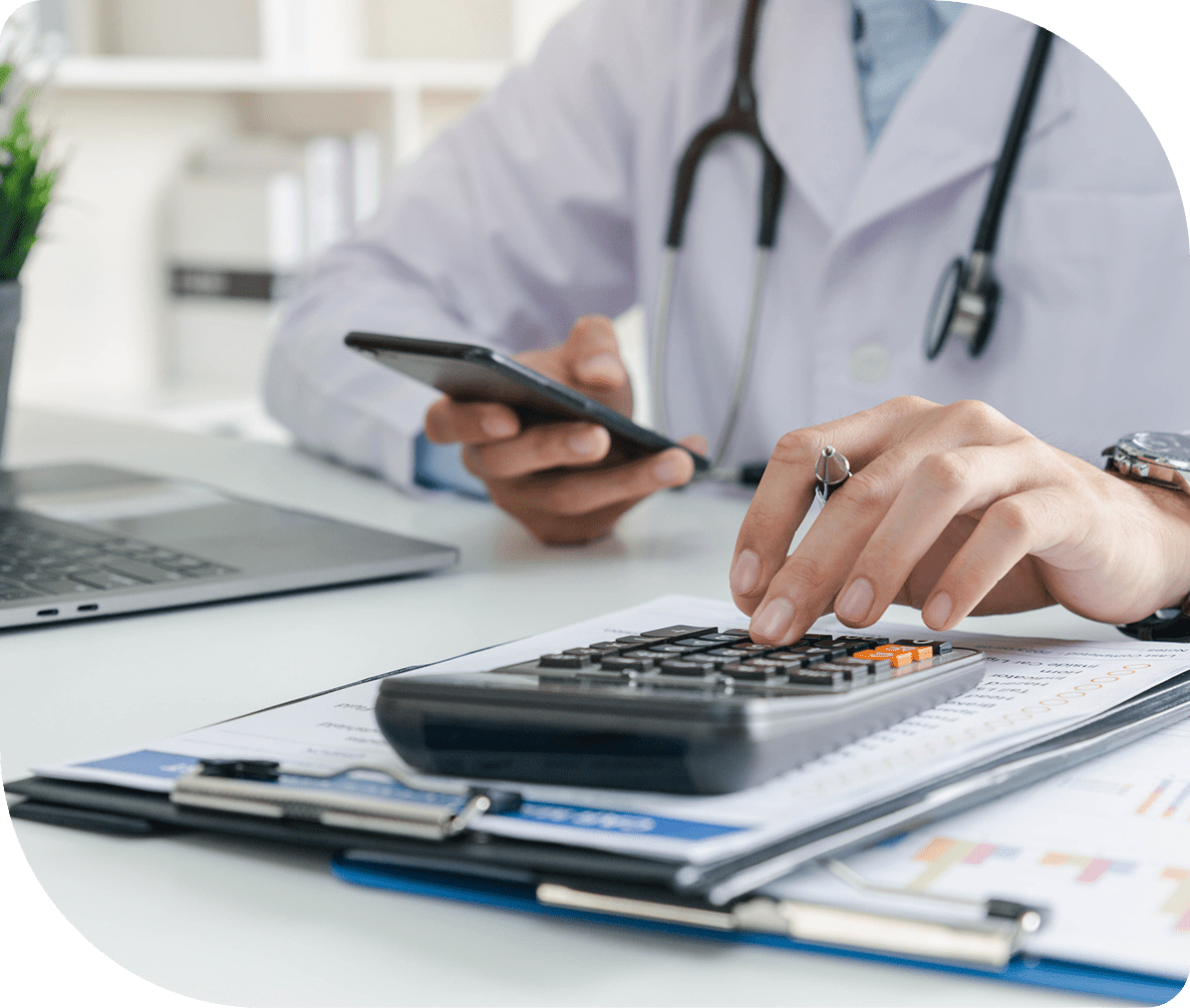 Doctor using phone and calculator in office.